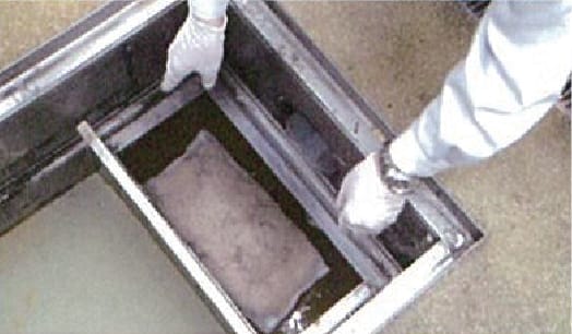 残渣カゴを戻す前に新しいエコツーネットを1槽目に設置し、浮上油を吸着させる。